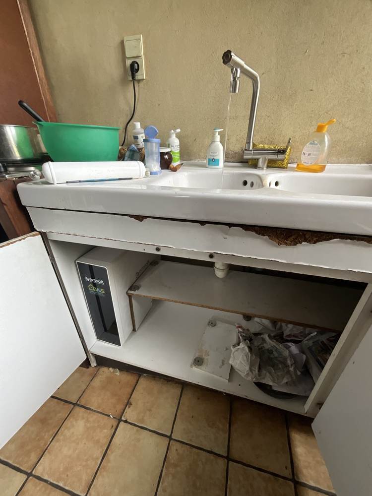 Robinet d'eau osmosée en fonctionnement sur un plan de travail sombre